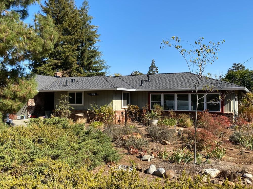 Modern single-story home with lush landscaping and clear blue sky. Ideal for family living.